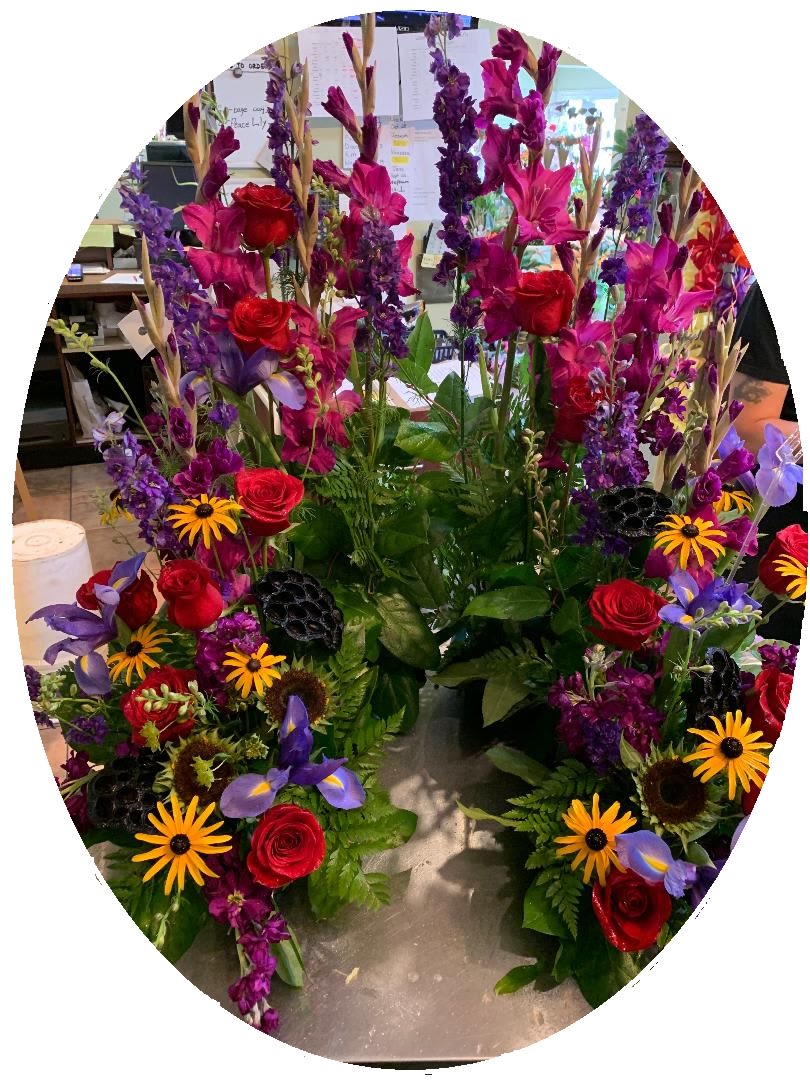 Tall mixed floral arrangement with red roses and purple blooms