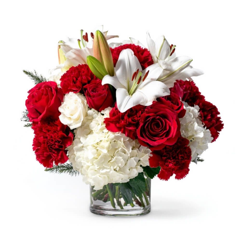 Red roses, white lilies, and carnations in a glass vase