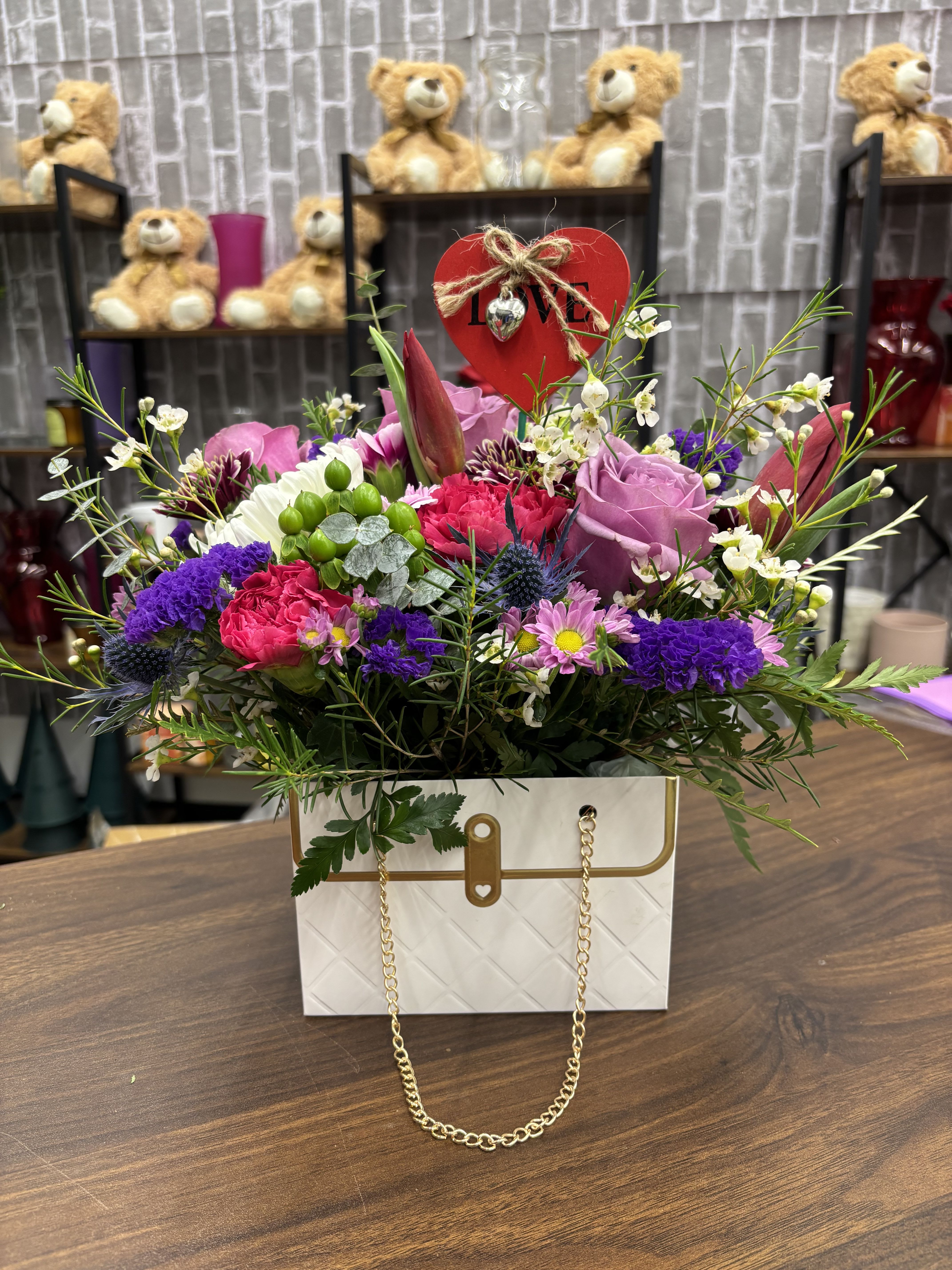 Mixed bouquet in a white gift bag with a red heart topper