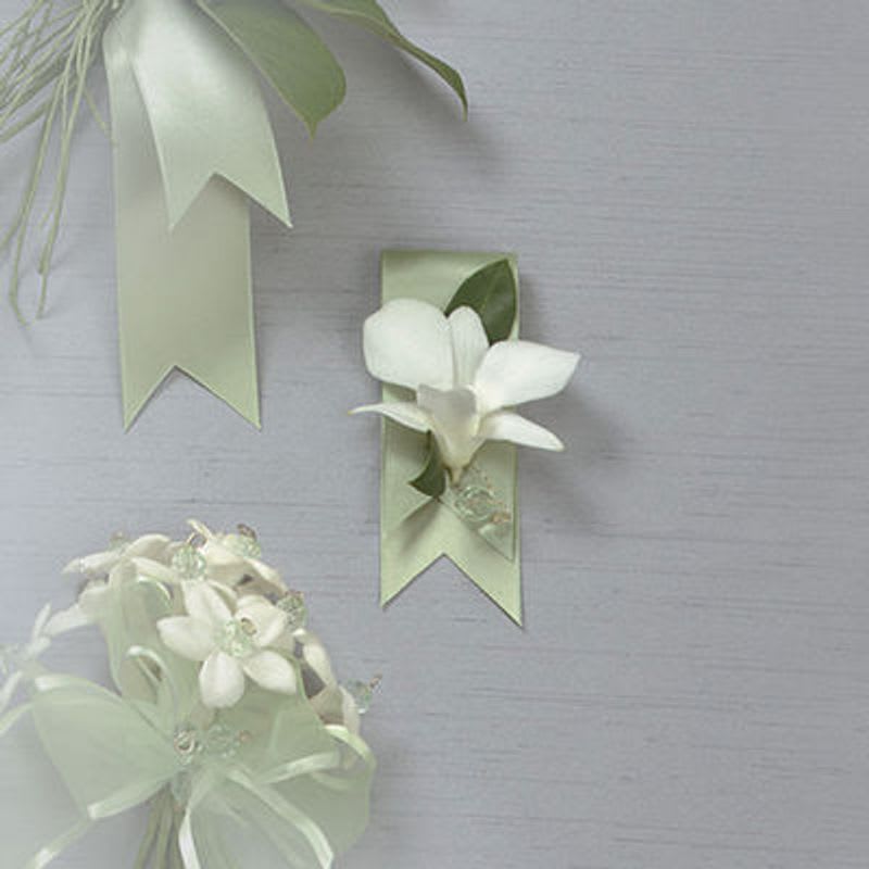 White floral corsage and ribbon boutonniere on pale green ribbons