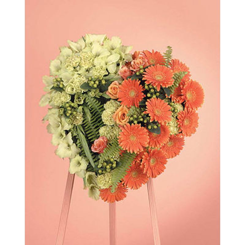 Heart-shaped floral arrangement with orange and pale green flowers on a stand