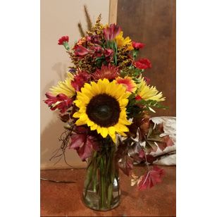 Mixed bouquet with a large sunflower in a glass vase