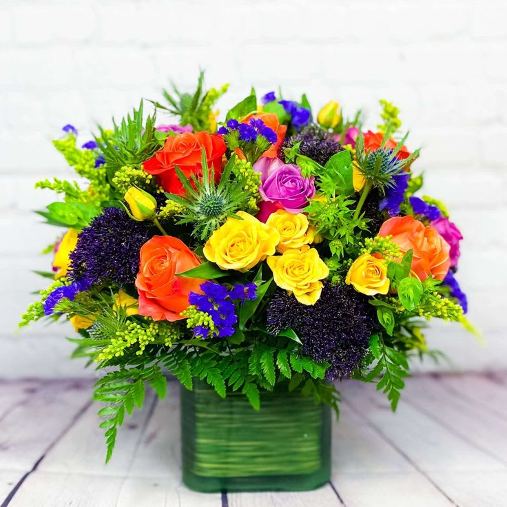 Colorful rose bouquet in a green square vase