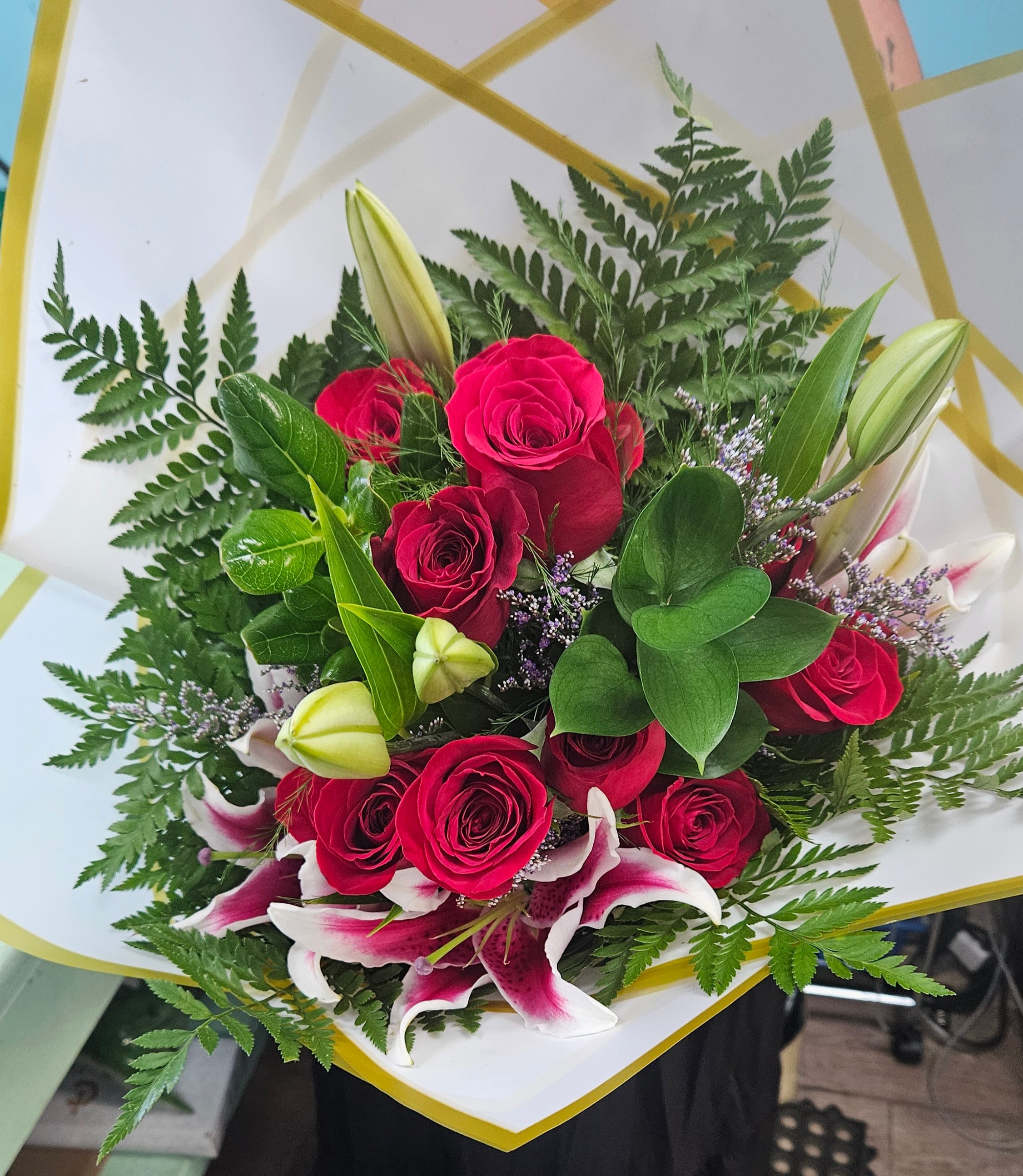 Bouquet of red roses and pink lilies with fern foliage