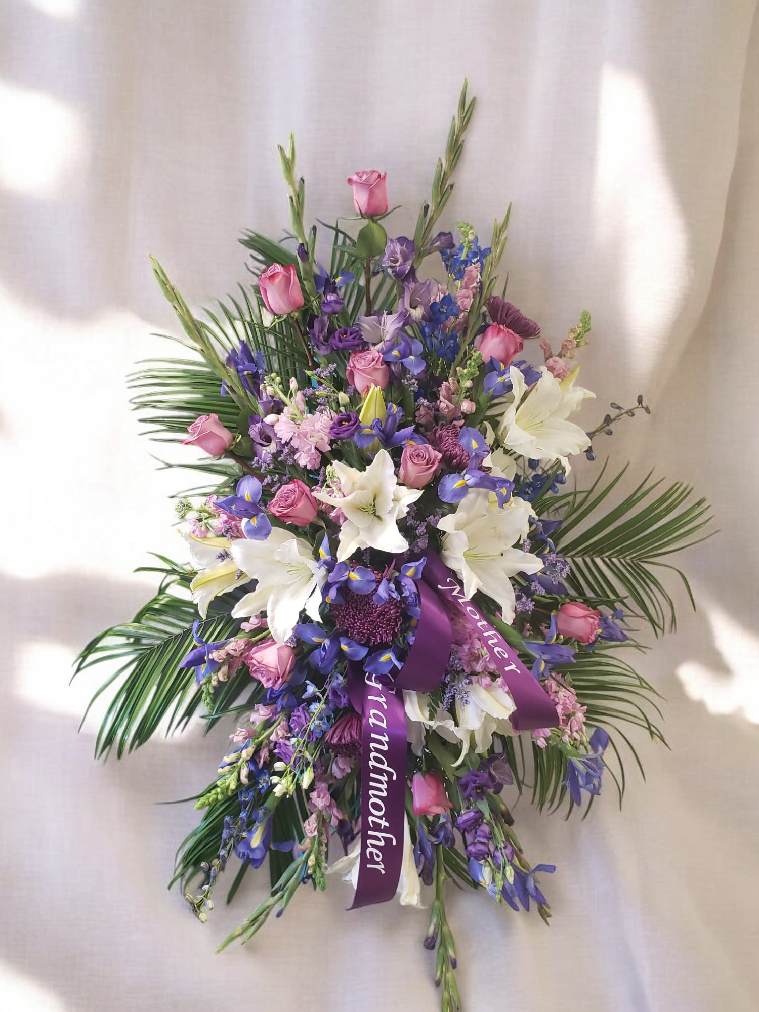 Purple and pink floral spray with white lilies and roses
