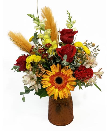 Mixed bouquet with red roses and a yellow gerbera daisy in an amber vase