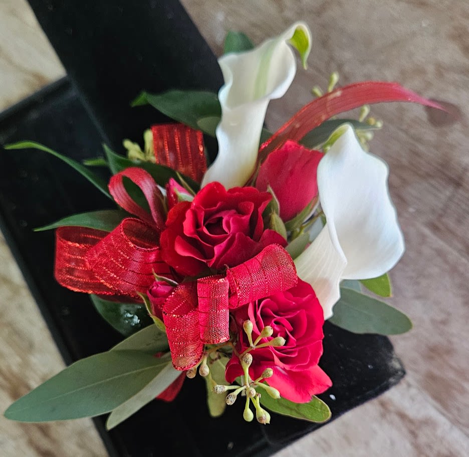 Small bouquet with red roses and white calla lilies tied with a red ribbon