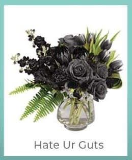 Black floral arrangement in a glass vase with green foliage