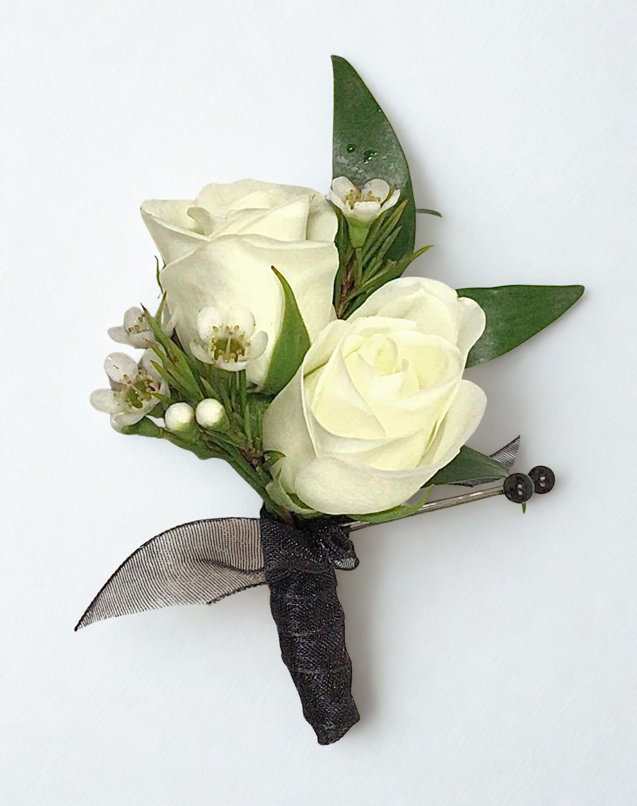 White rose boutonniere with small white blossoms and dark ribbon wrap