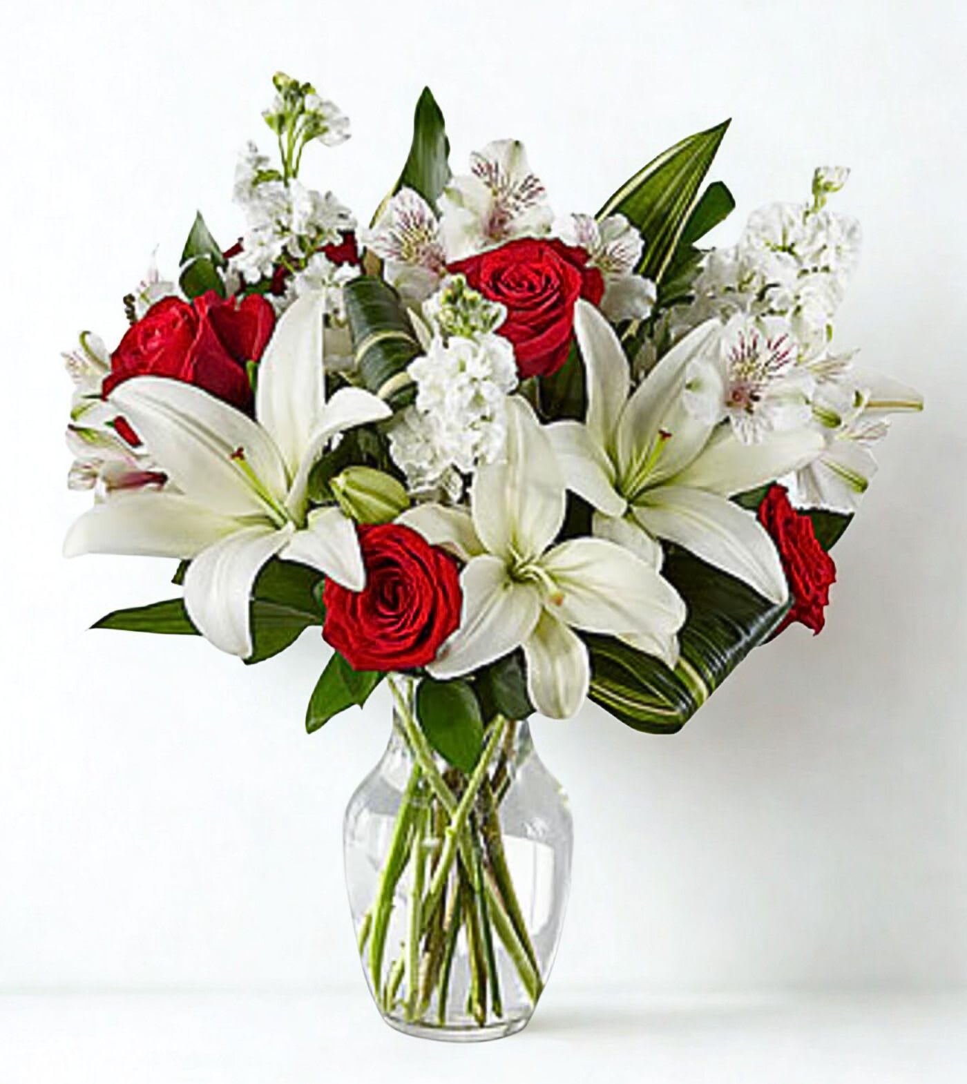 Red roses and white lilies in a clear glass vase