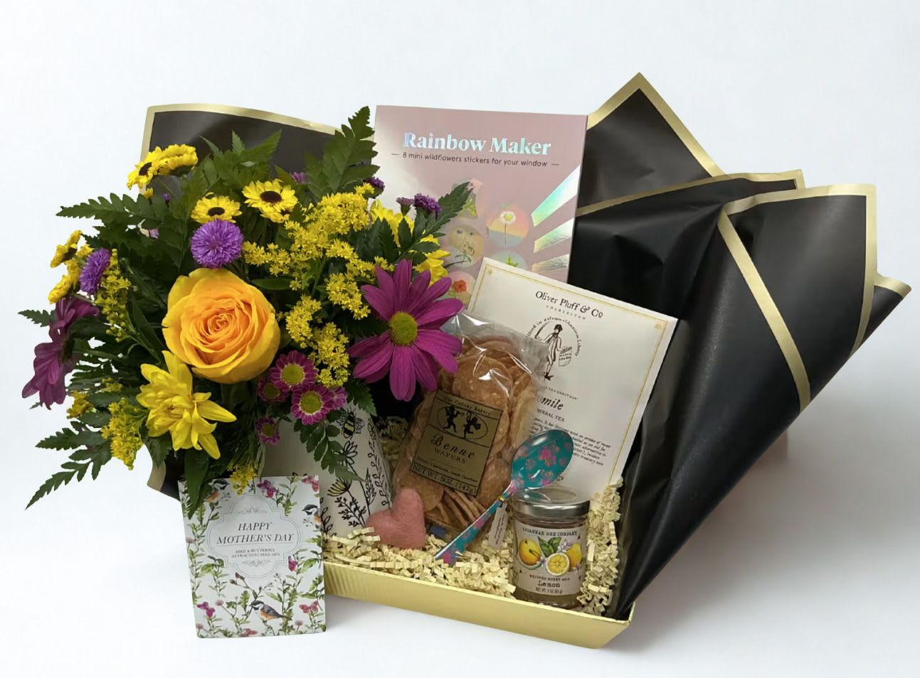 Blooms &amp; Brews - Celebrate Mom with a quiet moment just for her with our Blooms &amp; Brew Box — a cozy, thoughtful gift made for Mother’s Day.  Inside, she’ll find a keepsake mug filled with beautiful blooms and paired with soothing tea, honey, and benne cookies for the perfect relaxing moment. To brighten her day, we’ve included rainbow maker wildflower stickers—playful, cheerful accents that bring a little extra sunshine to her space.    Full of little joys, the Bloom Box is a simple way to remind Mom to slow down and savor a moment for herself.