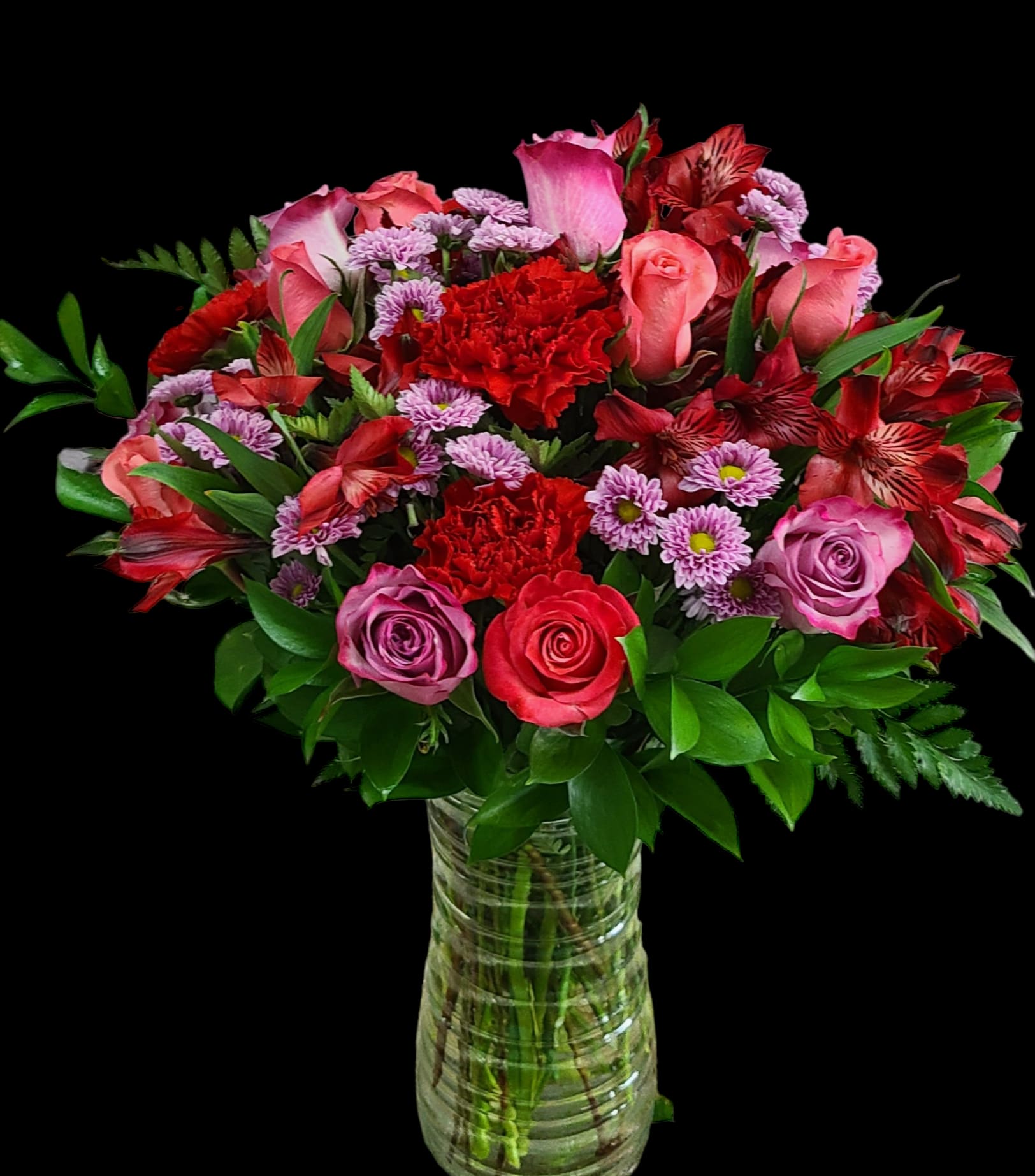 Bouquet of pink and red roses with carnations in a glass vase