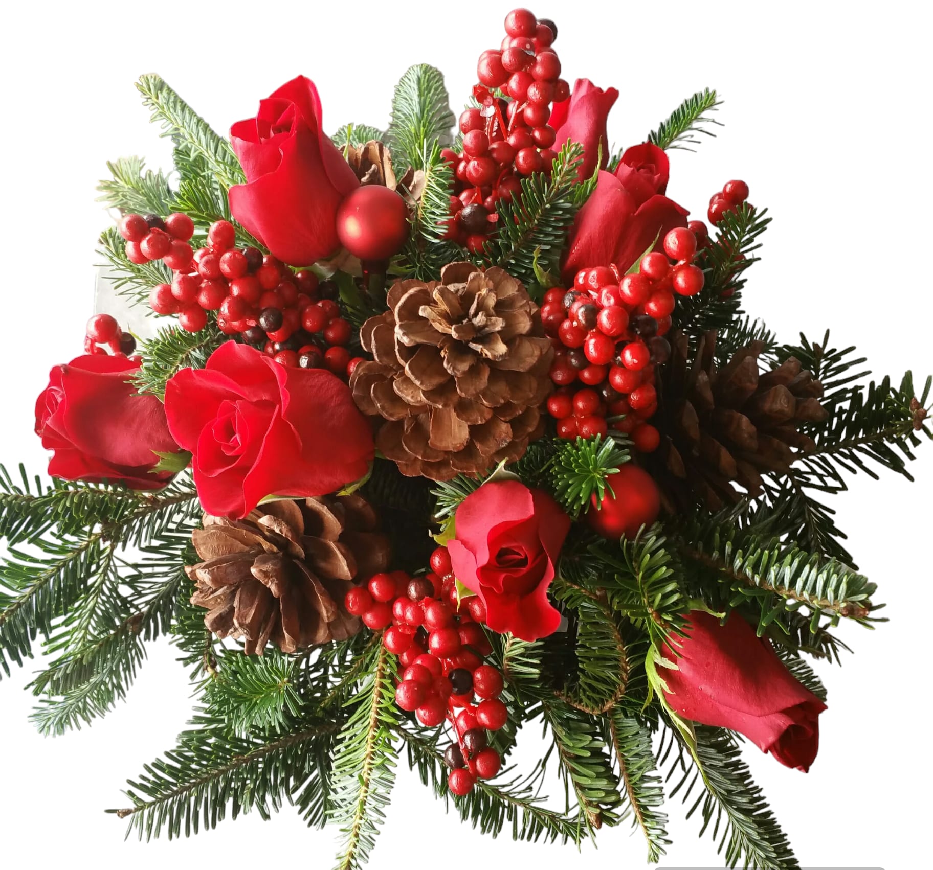Red roses with pinecones and berries in a holiday bouquet