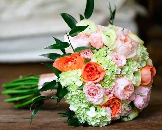 Bouquet of peach and pink roses with pale green hydrangeas