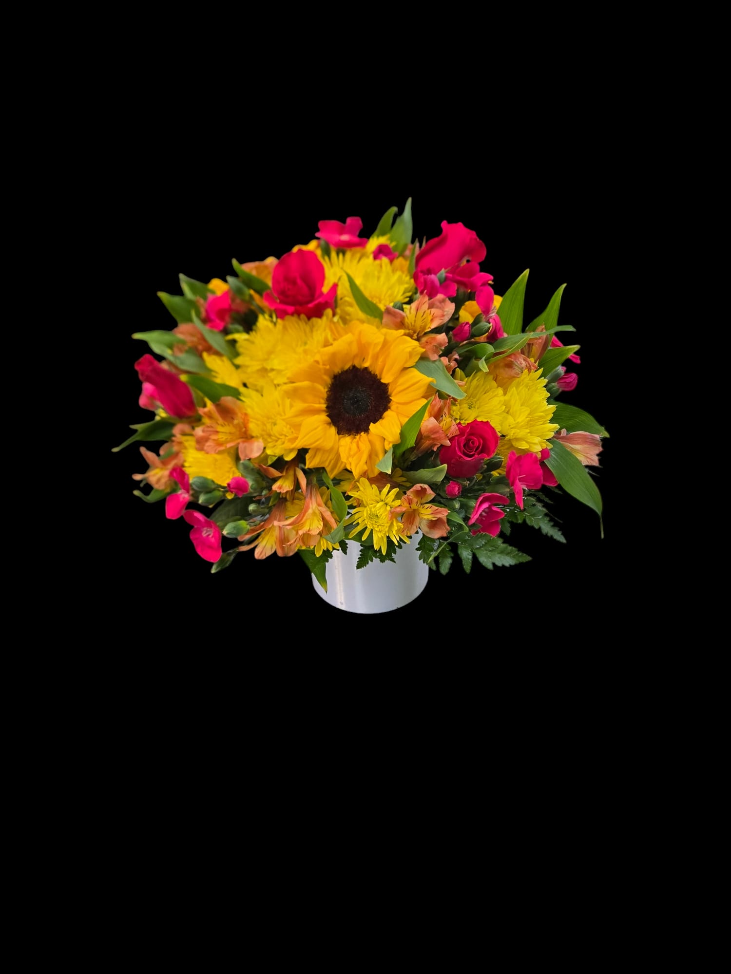 Bouquet of yellow sunflowers and pink flowers in a white vase
