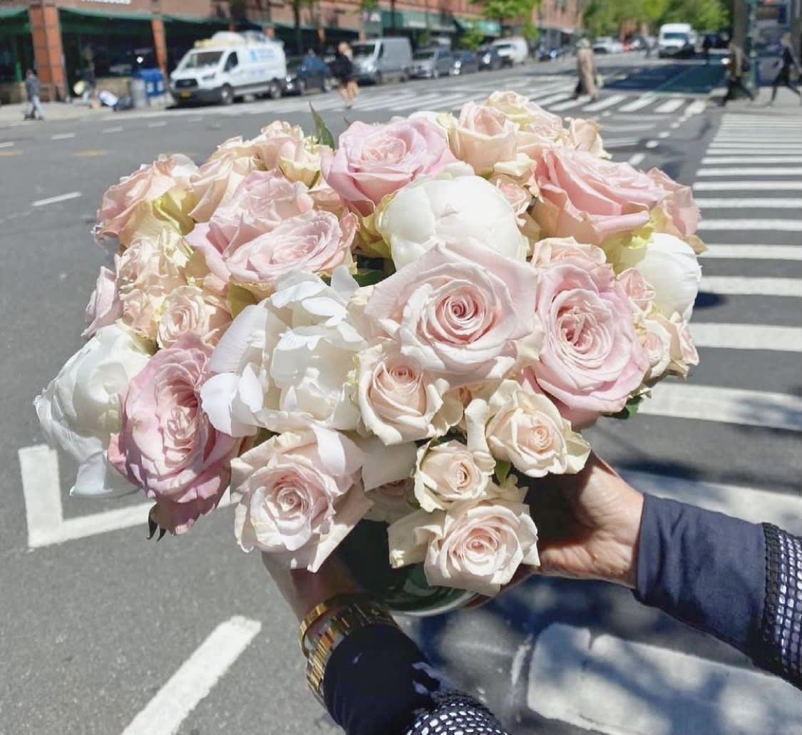Handheld bouquet of pale pink and white roses