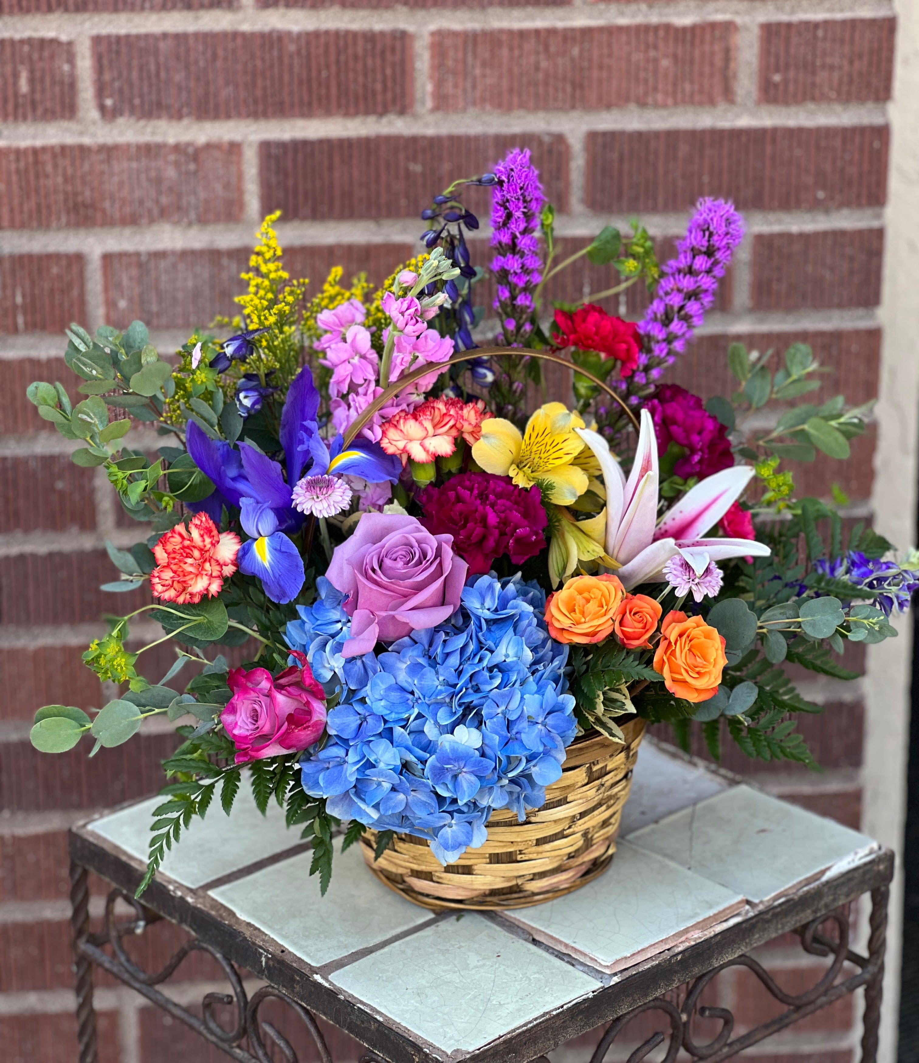 Colorful mixed flower arrangement in a woven basket