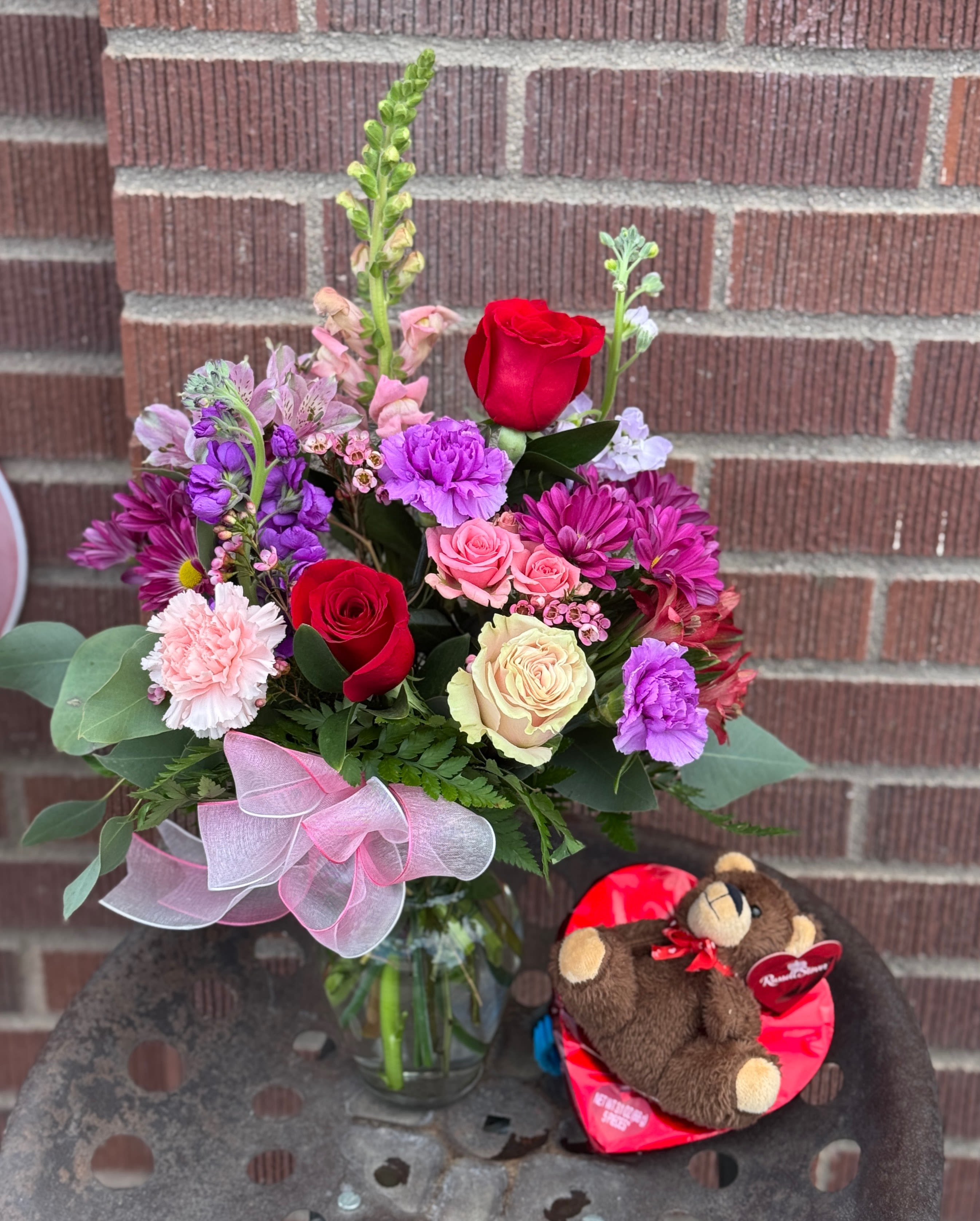 Mixed bouquet in a glass vase with a teddy bear gift