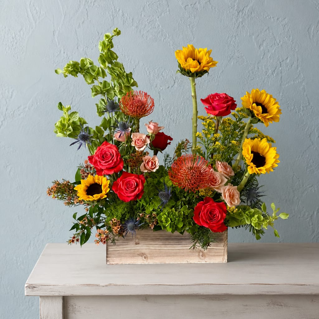 Mixed bouquet in a wooden box with roses and sunflowers