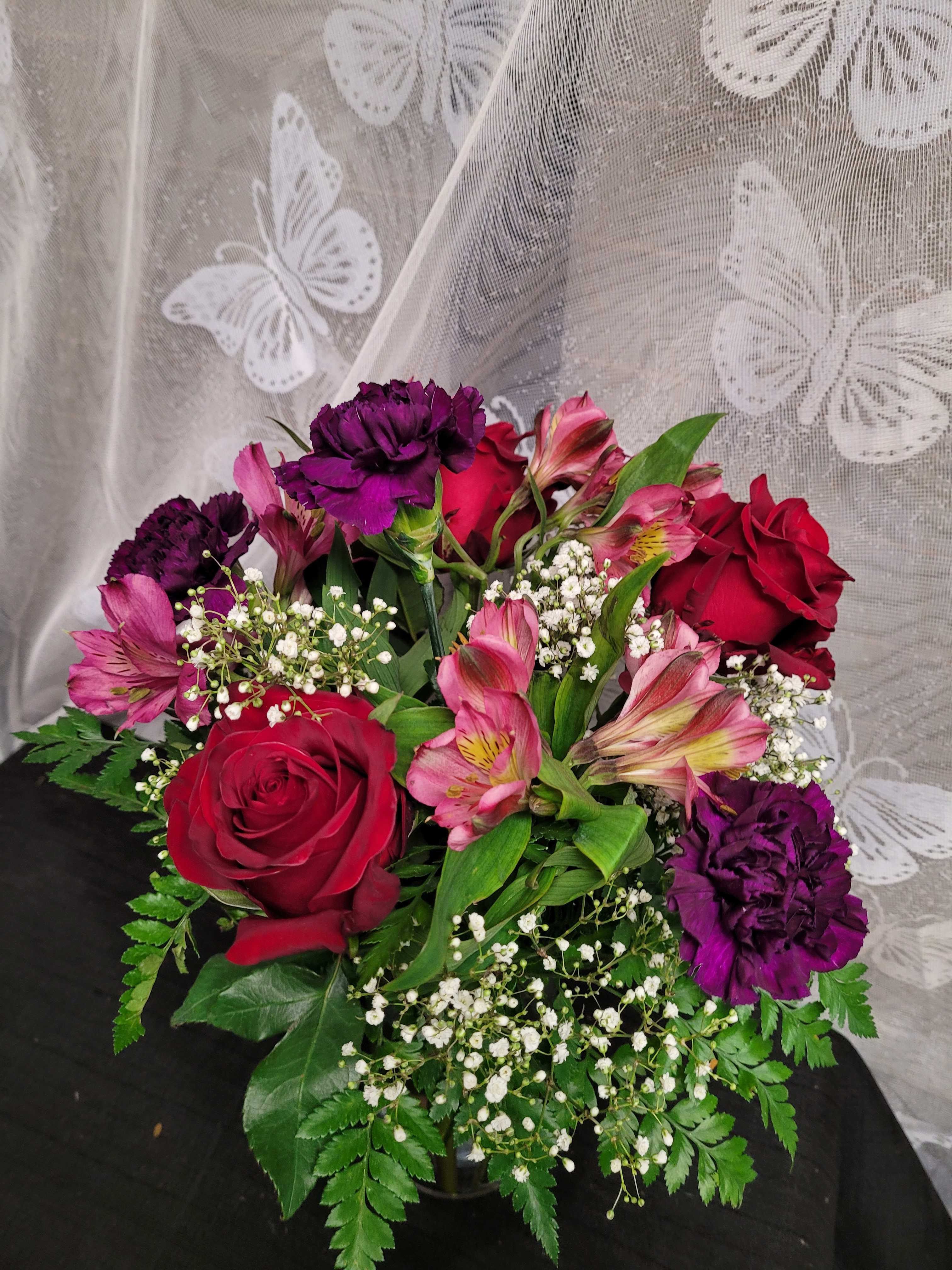 Bouquet of red roses, pink alstroemeria, and purple carnations