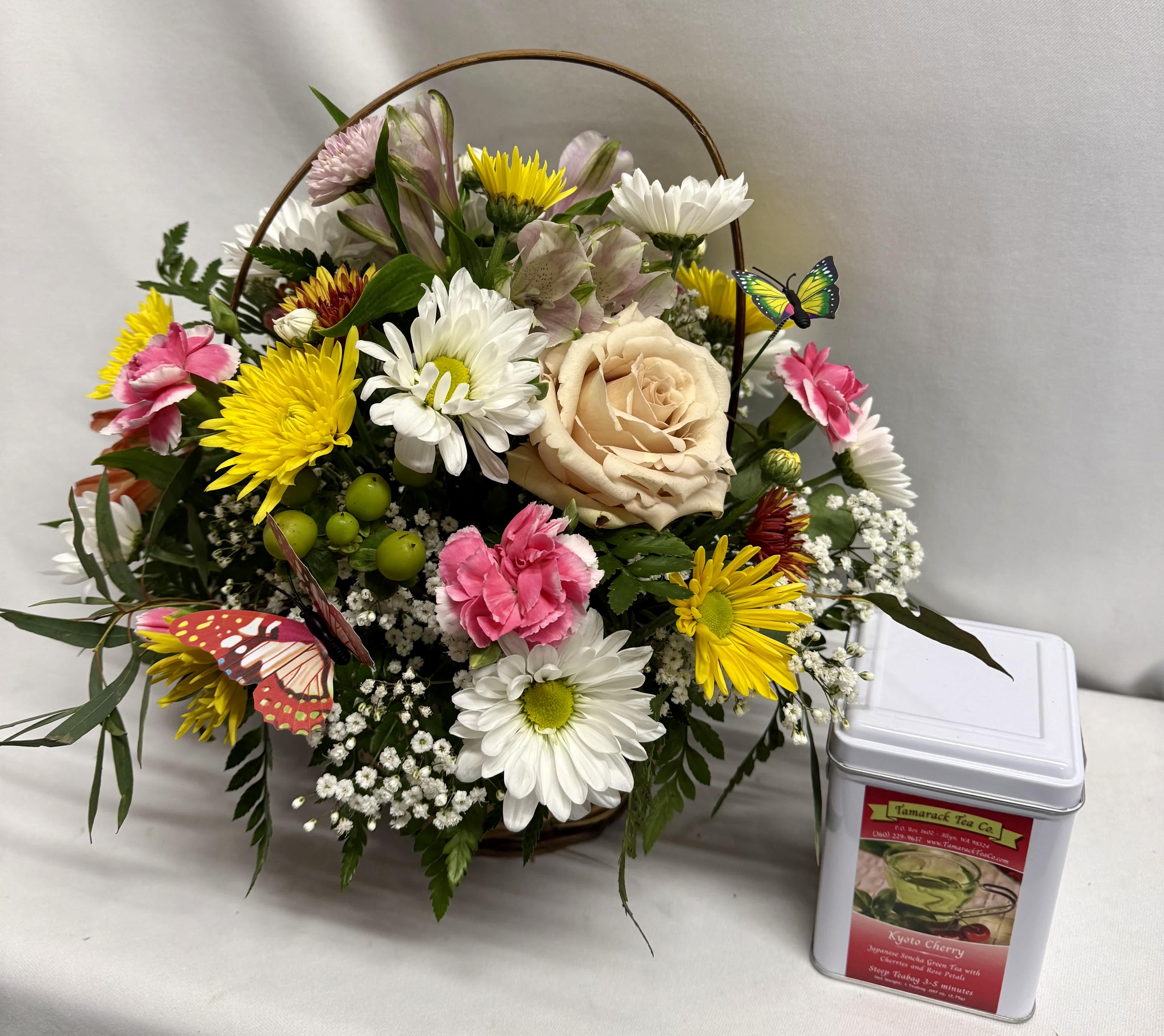 Mixed bouquet with a peach rose, daisies, and pink carnations in a basket