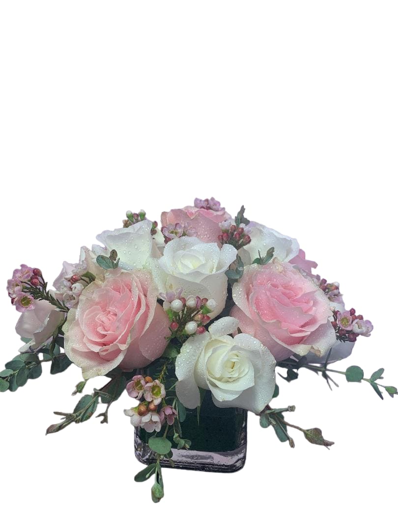 Pink and white rose bouquet in a square glass vase