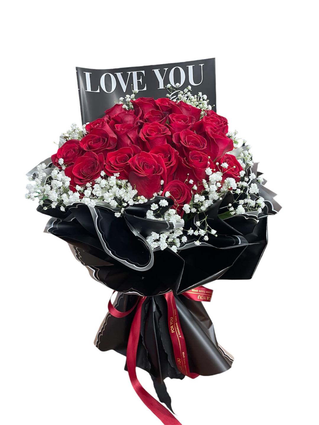 Bouquet of red roses with white baby's breath and a LOVE YOU sign