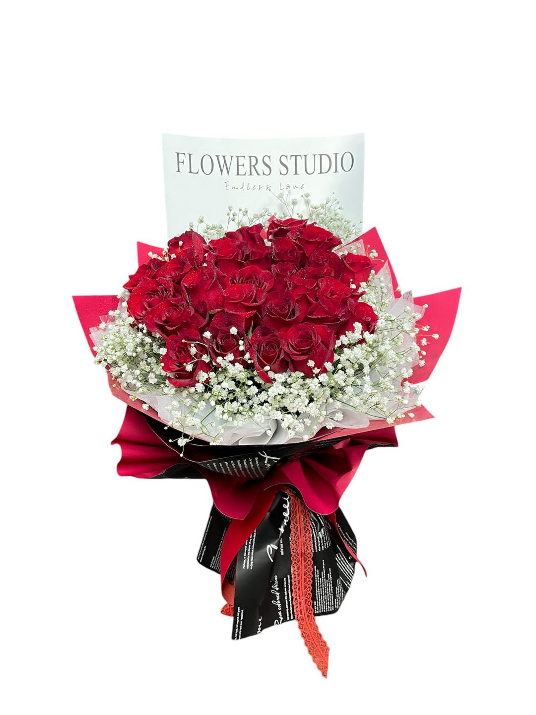 Bouquet of red roses with white baby's breath and red wrapping