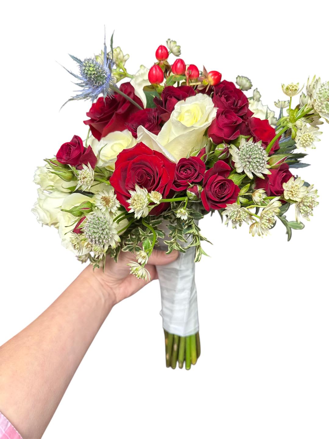 Handheld bouquet of red and white roses with small accent flowers