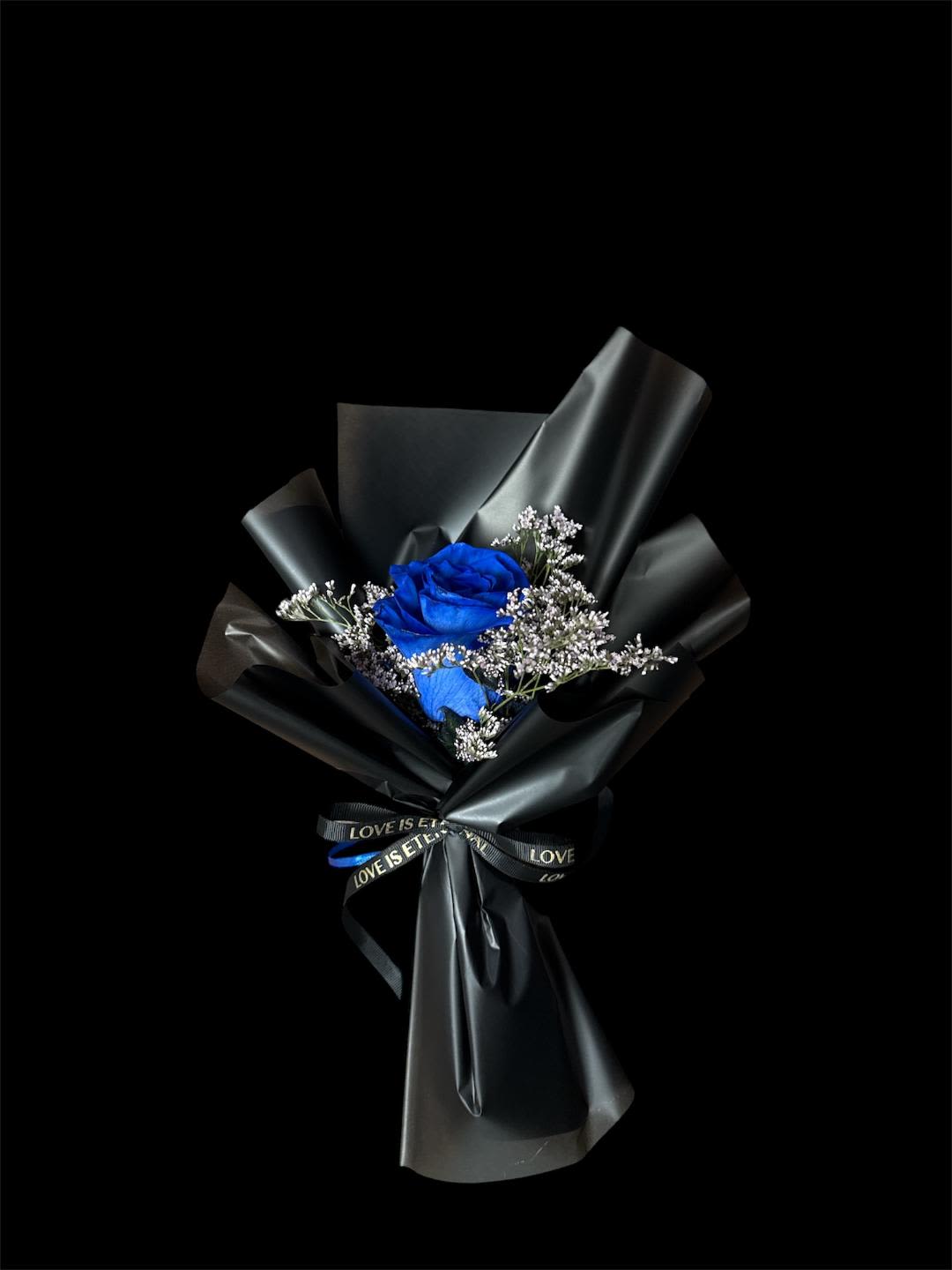 Blue rose bouquet wrapped in black paper with a ribbon