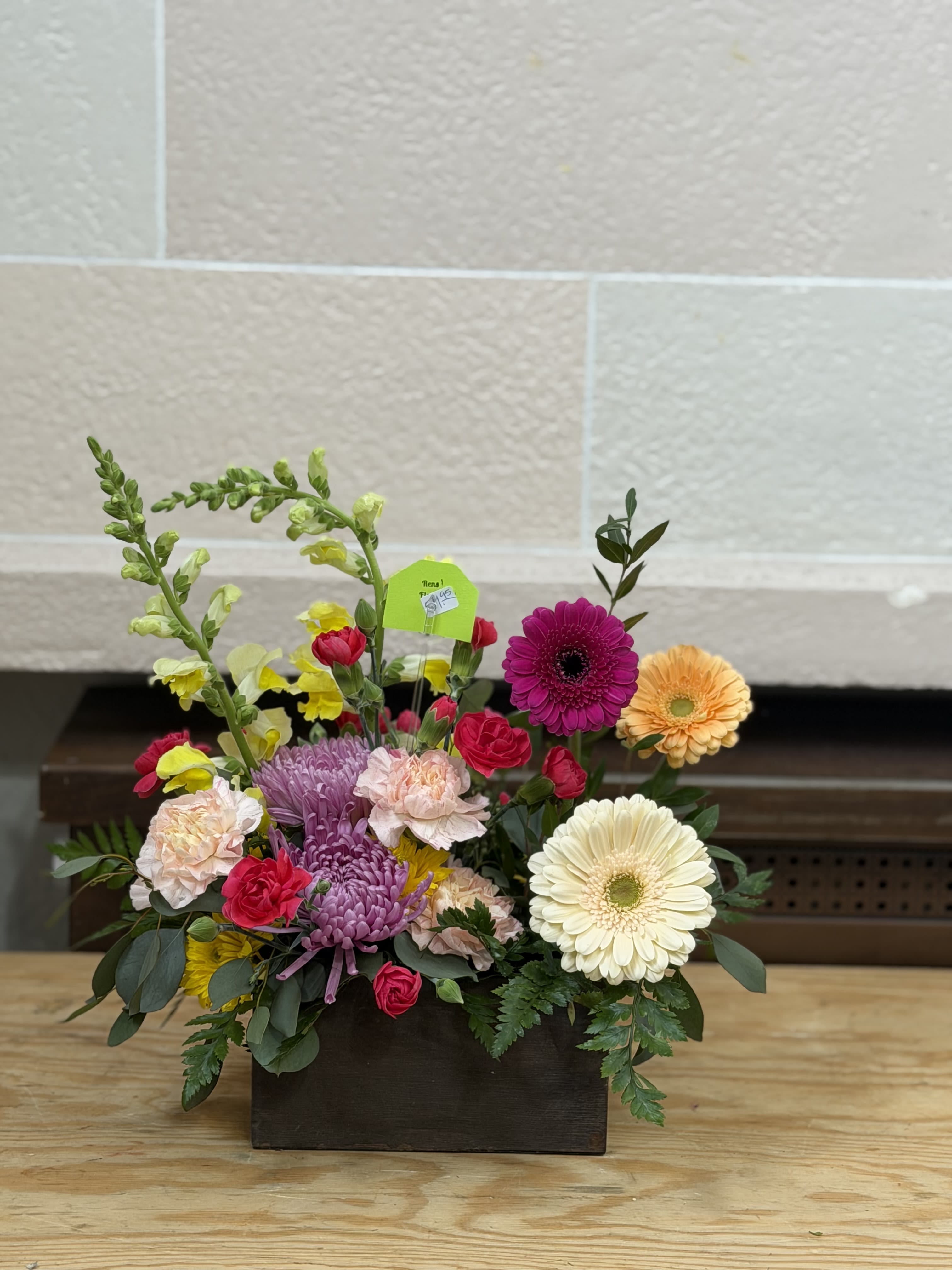 Mixed flower arrangement in a dark rectangular container