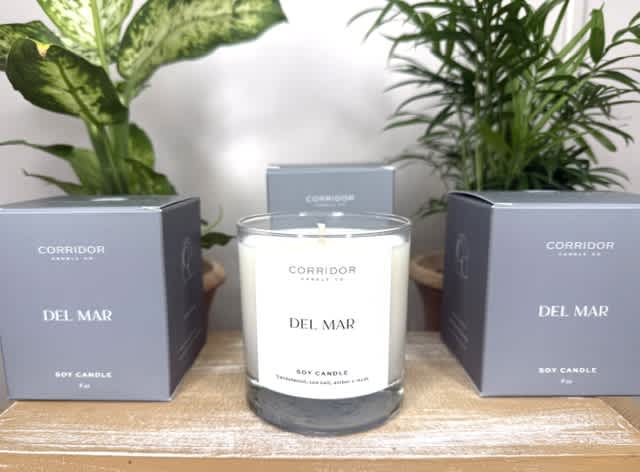 Soy candle in a glass jar with two matching boxes beside it