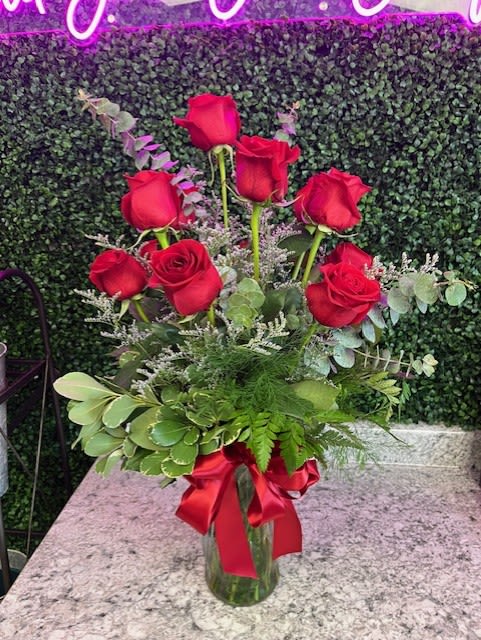 Red roses in a glass vase with a red ribbon