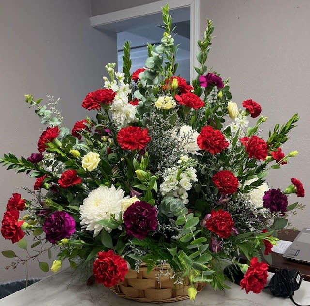 Large basket arrangement of red, white, and purple flowers