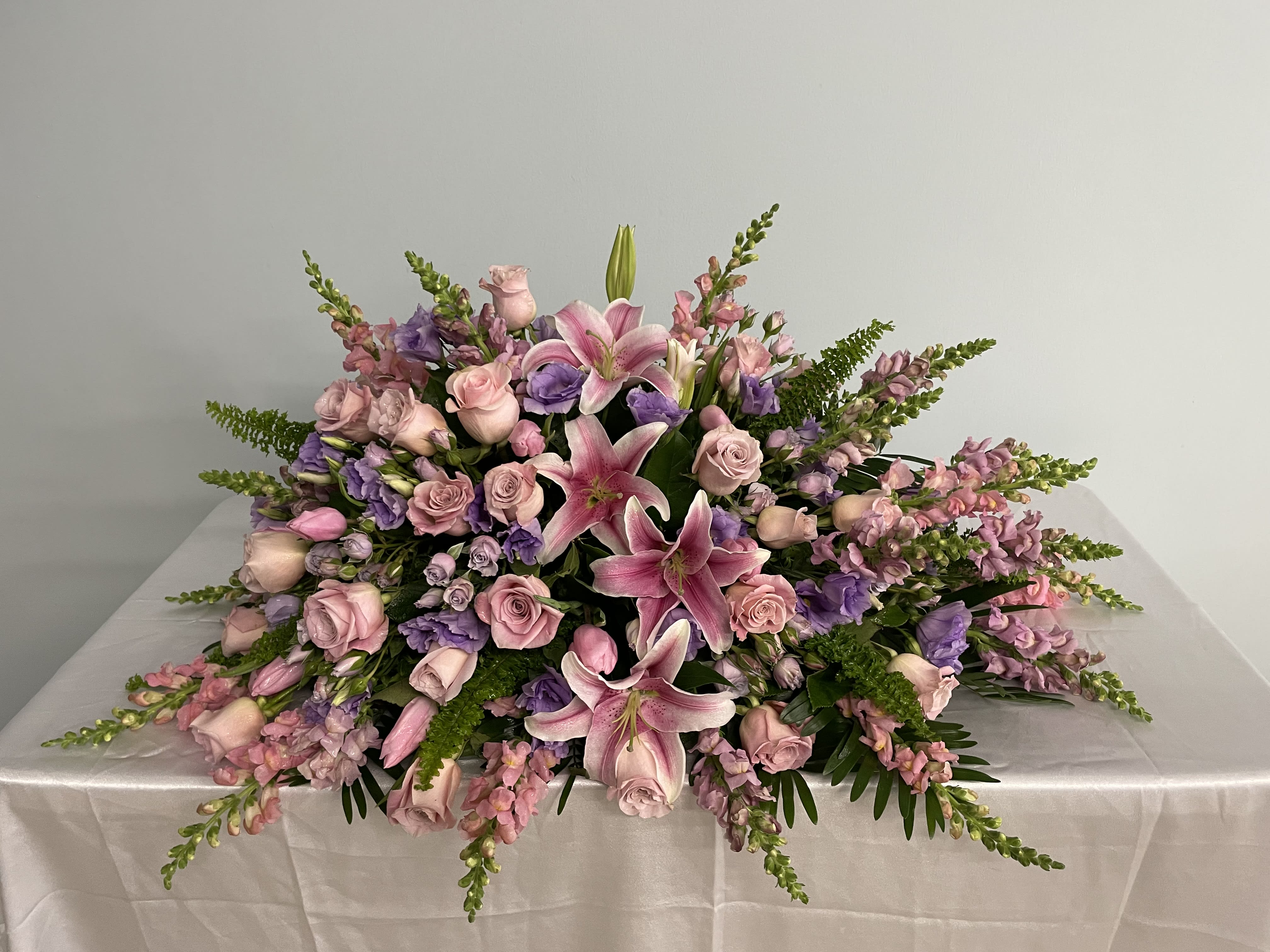 Low floral centerpiece with pink lilies, roses, and purple blooms