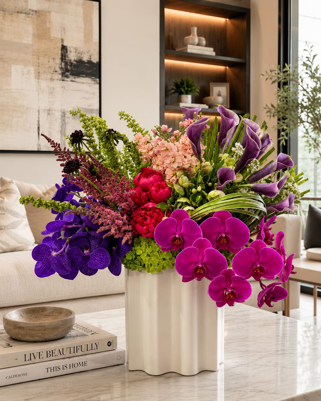 Large arrangement of purple orchids, calla lilies, and pink flowers in a white vase