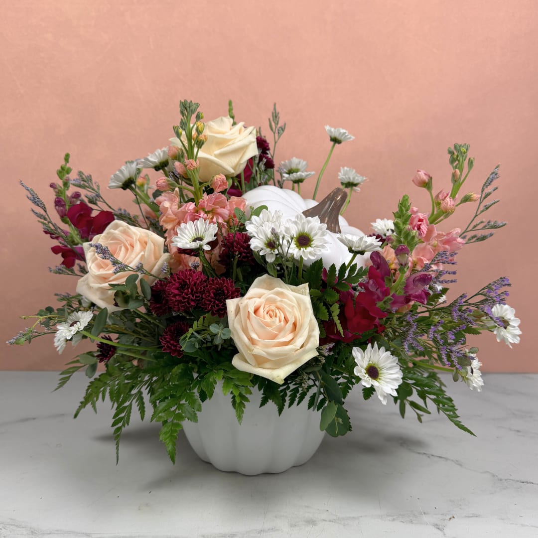 Mixed bouquet in a white pumpkin vase with cream roses and white daisies