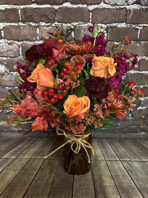 Fall Mason - A beautiful array of Fall flowers fill this mason jar that is adorned with a metal leaf.  Flowers and colors will vary. Approx 16" H x 15" W