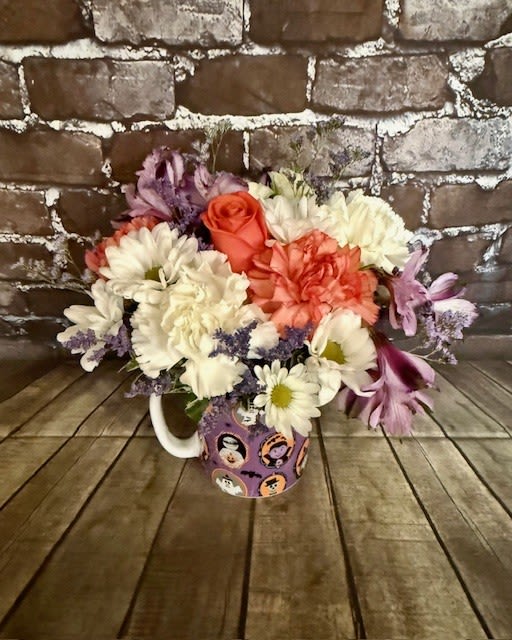 Monsters Brew - An adorable Halloween mug covered with classic monsters and filled with festive flowers.