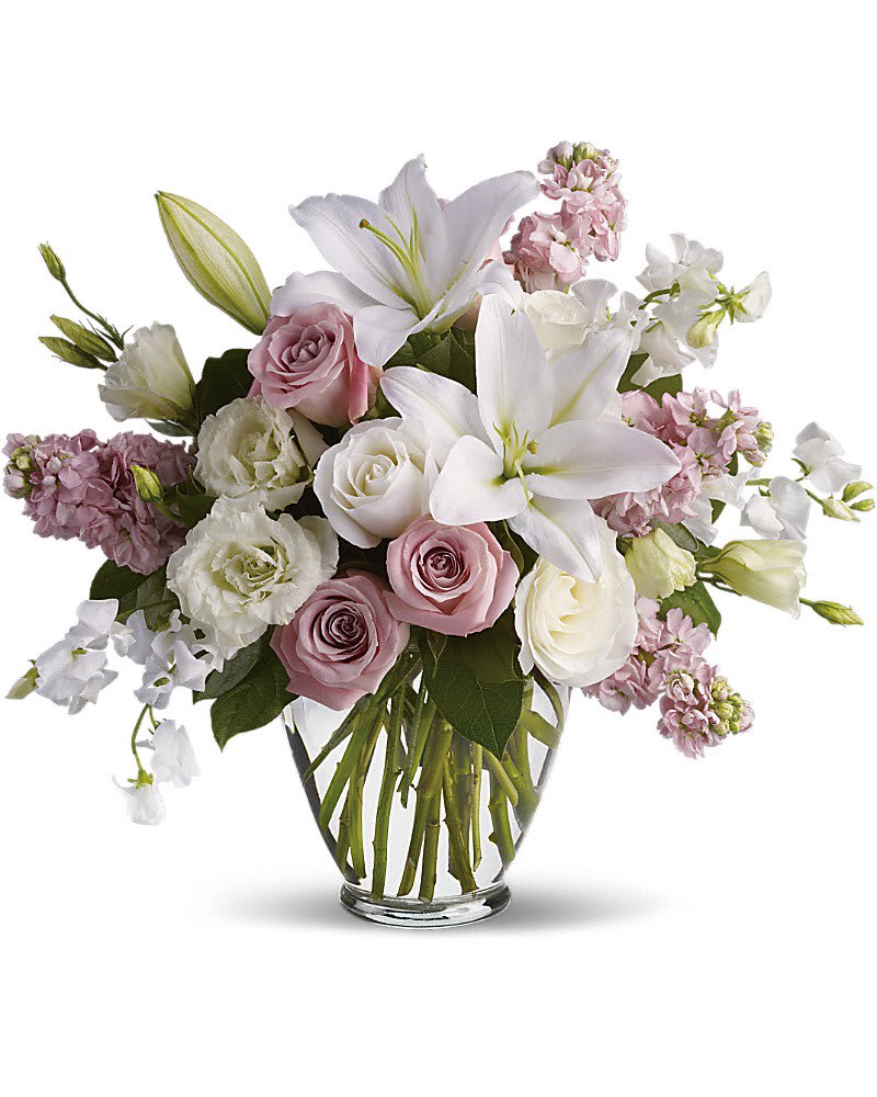Pink and white bouquet with lilies and roses in a clear glass vase