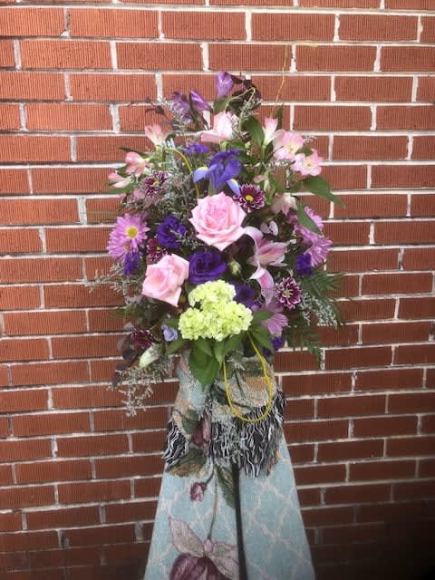 Tall mixed bouquet with pink and purple flowers in a decorative wrap