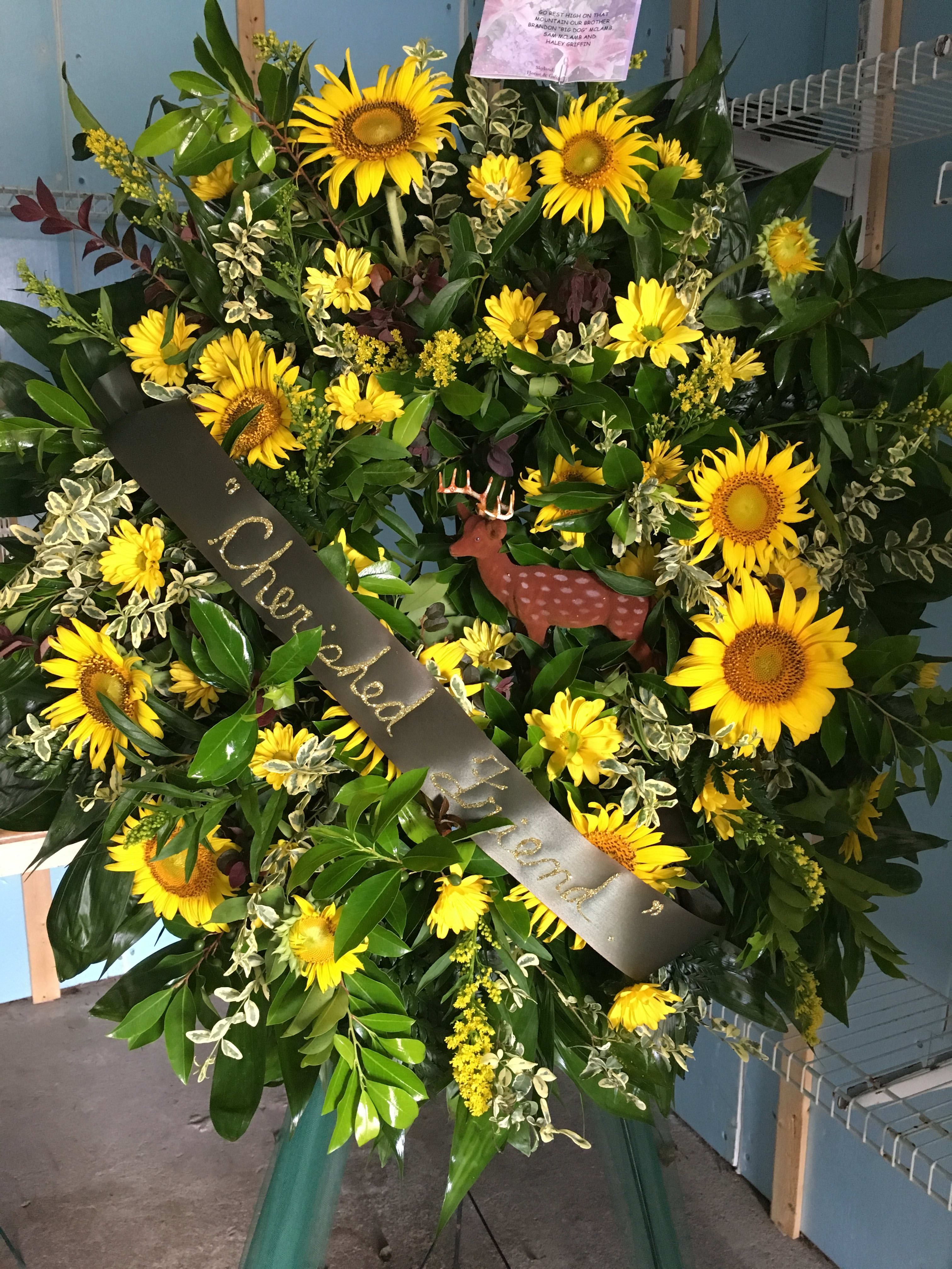 Large sunflower wreath with a black memorial ribbon and deer ornament