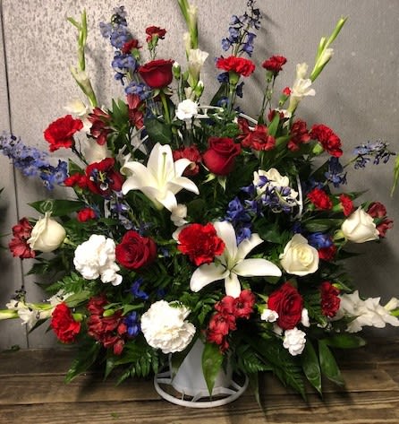 Large red, white, and blue floral spray in a white container