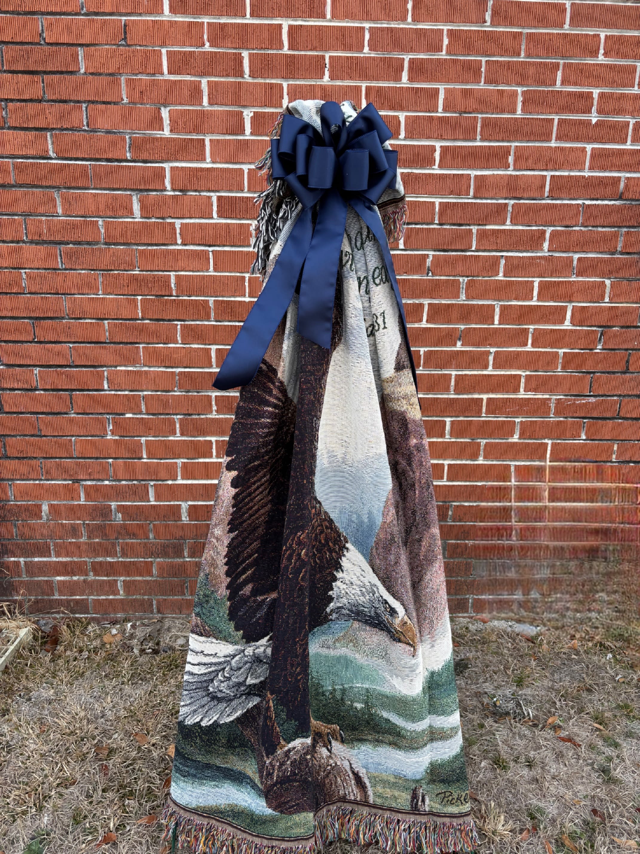 WOVEN BLANKET - A WOVEN BLANKET MADE IN THE MOUNTAINS OF NORTH CAROLINA DISPLAYED ON A STAND WITH A MATCHING BOW. VARIETY OF BLANKETS TO CHOOSE FROM.