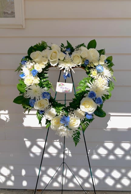 Elegant Heart-Shaped Standing Funeral Arrangement - An all white tribute, this white cross funeral spray is pure and tranquil. Featuring a variety of white flowers, this elegant easel compliments the beauty of life. 