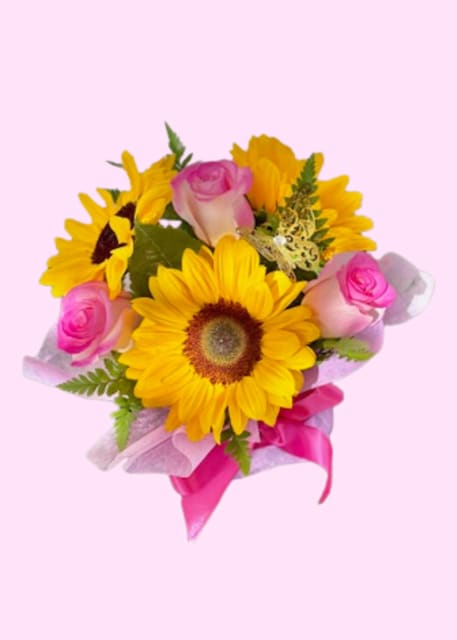 Bouquet of yellow sunflowers and pink roses with a pink ribbon