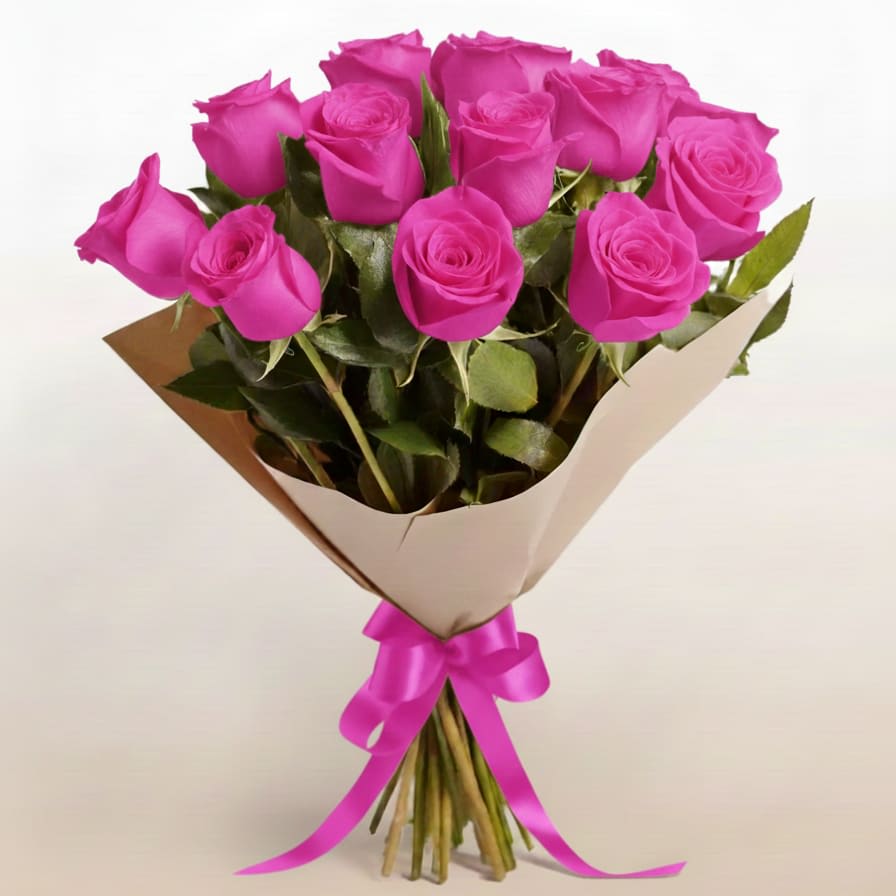 Bouquet of bright pink roses wrapped in paper with a pink ribbon