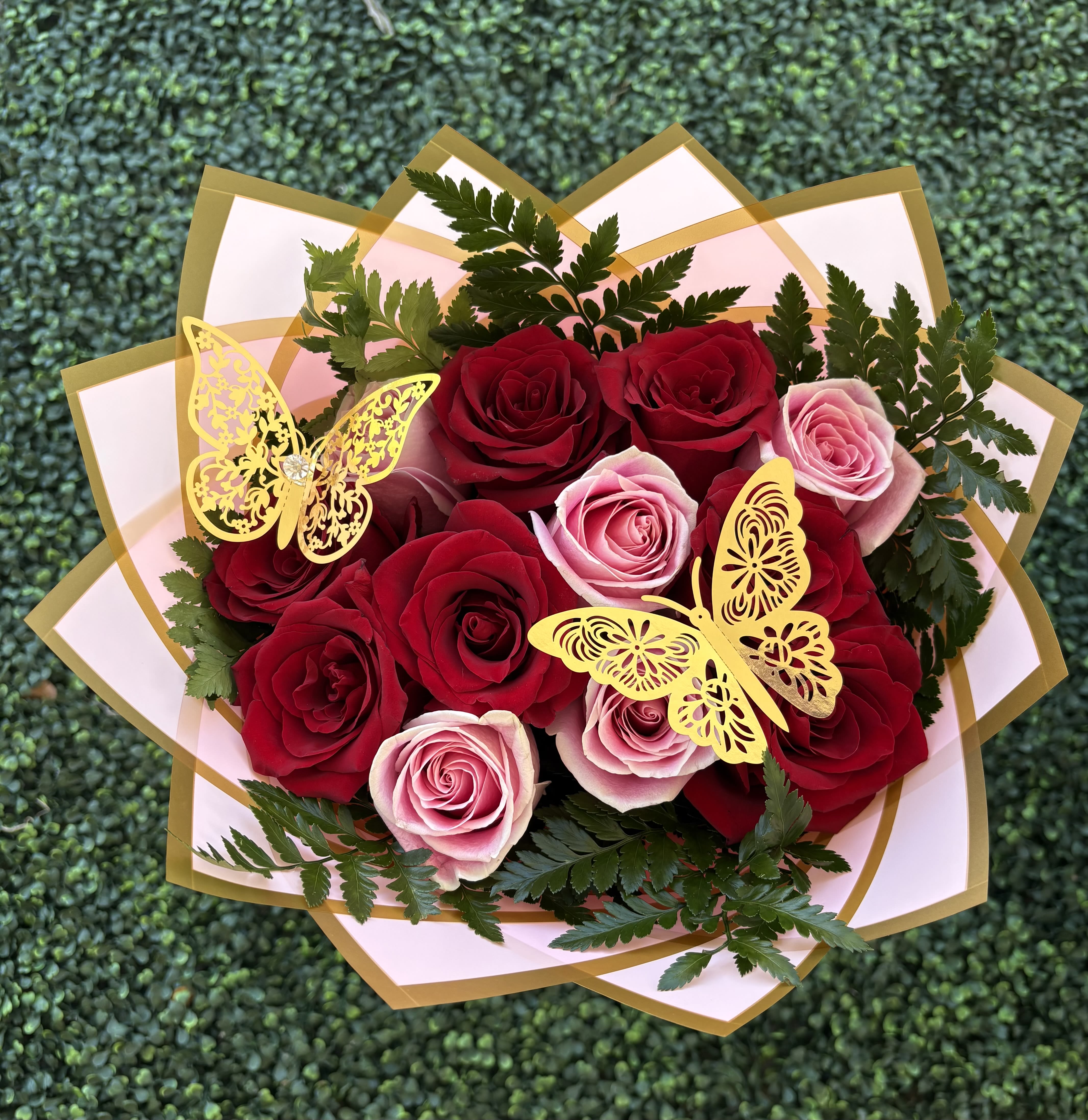 Bouquet of red and pink roses with gold butterfly decorations