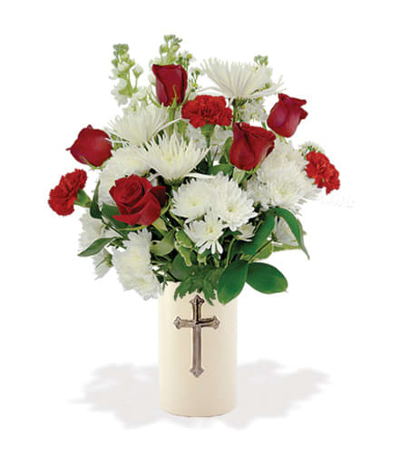 Red roses and white daisies in a cream vase with a cross emblem