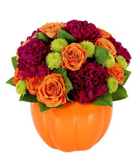 Orange and magenta flower arrangement in a pumpkin-shaped vase